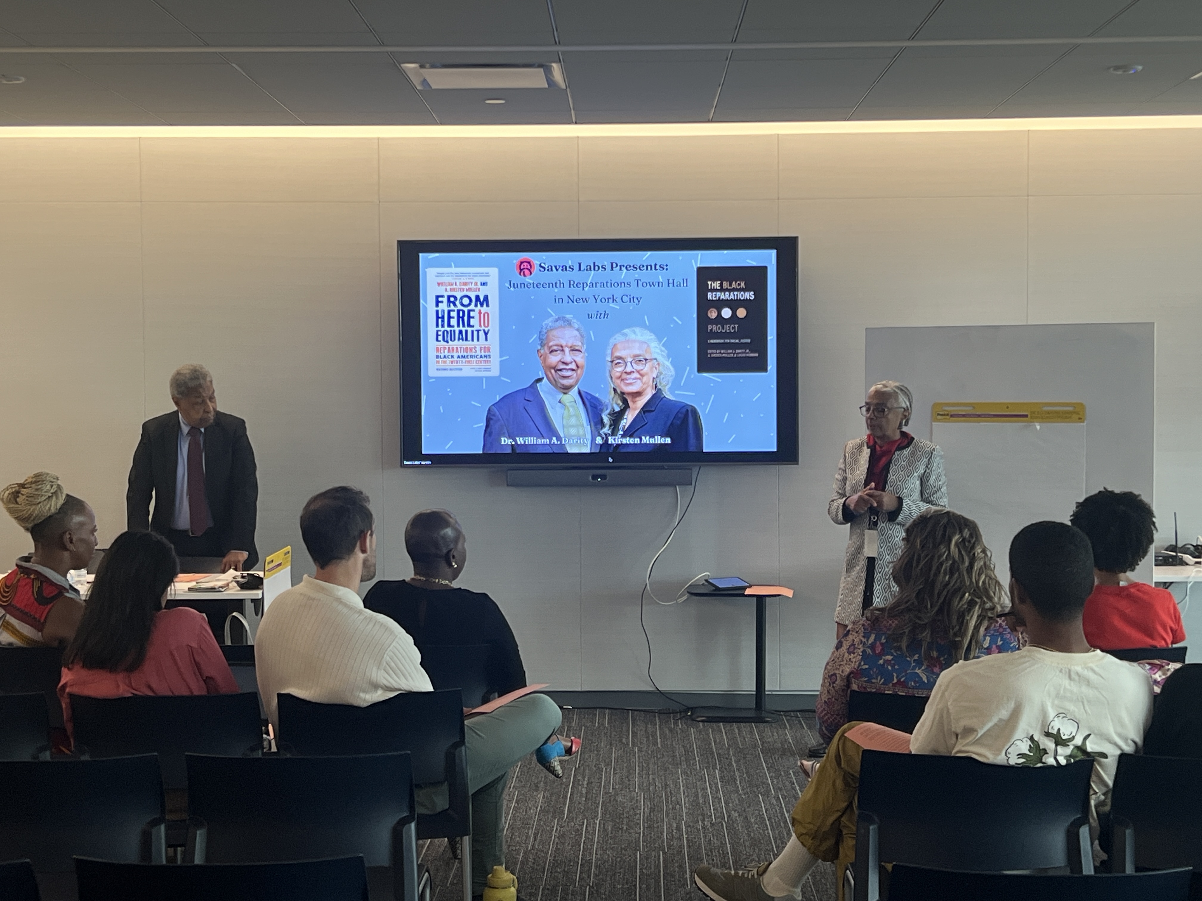 Dr. Darity and Kirsten standing and speaking to the group