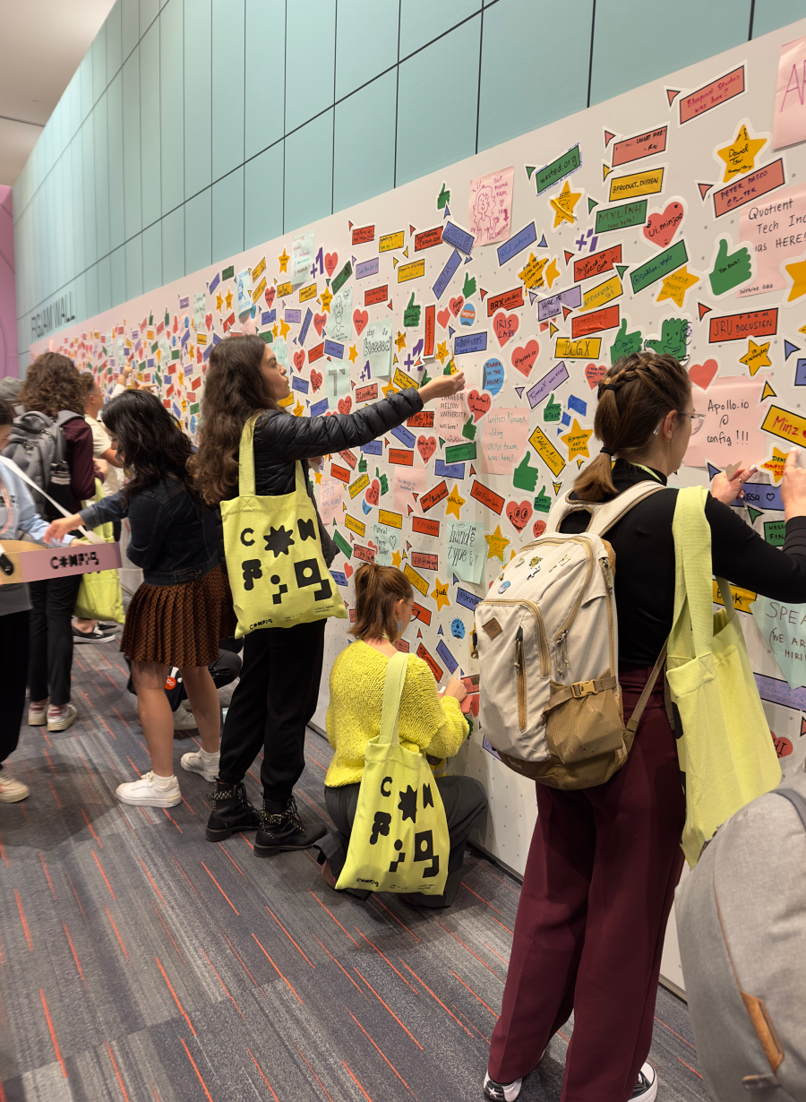 Conference attendees adding their names to the wall