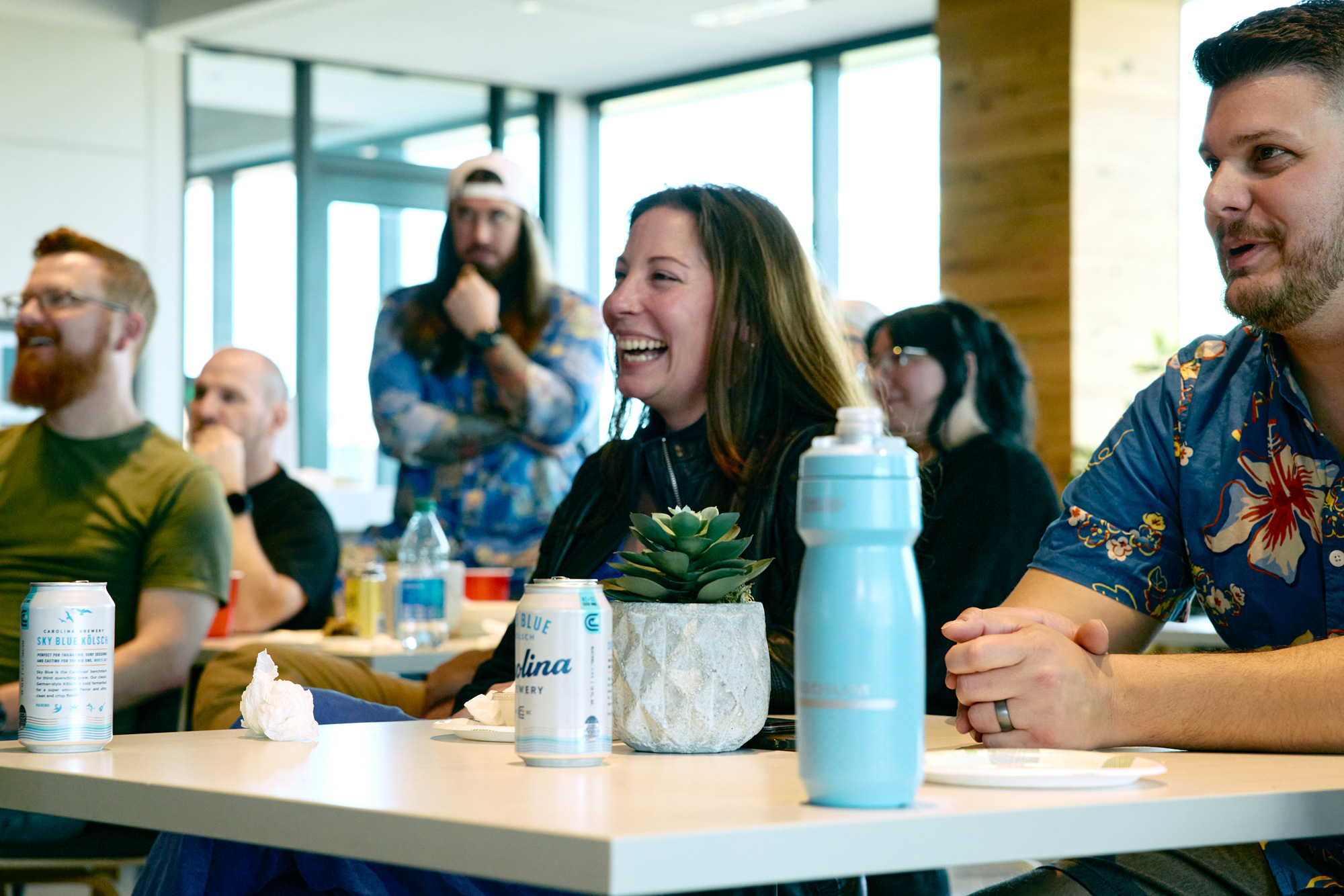 A Few Folks from Savas Smile together while sitting down at an all company meeting.
