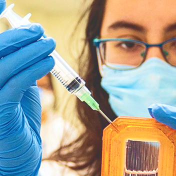 Student inserting a syringe into a container