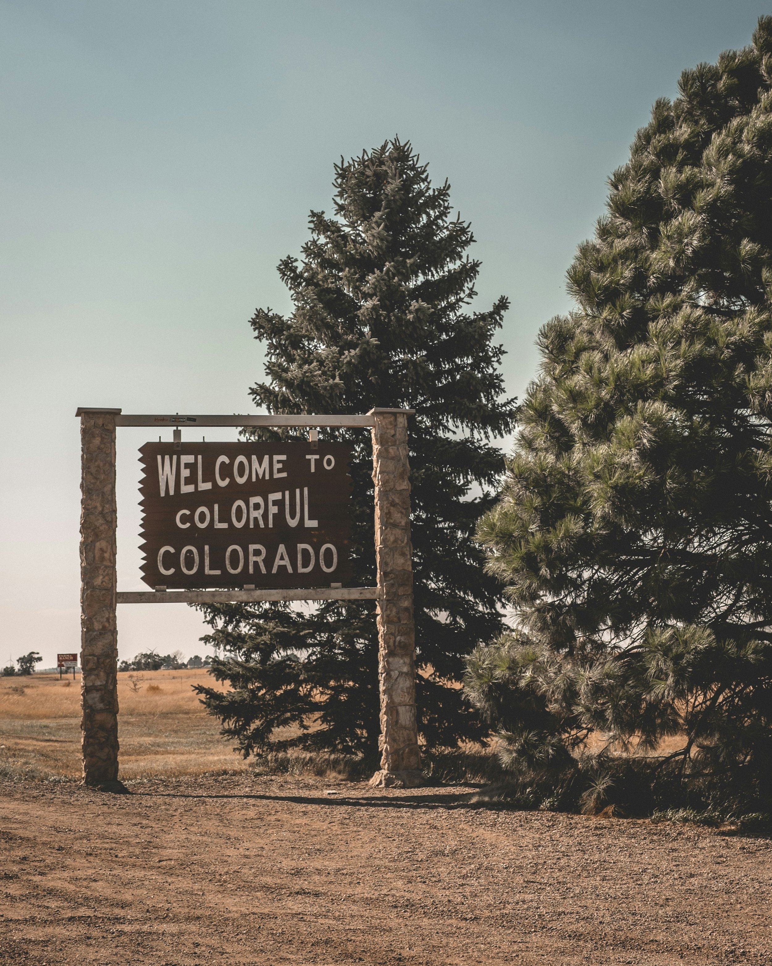 Welcome to Colorado sign with trees