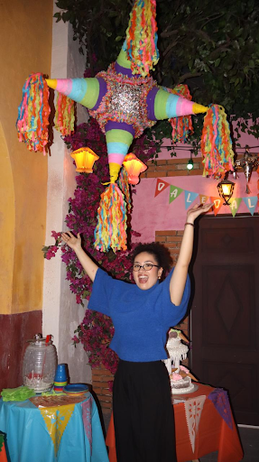 dioceline celebrating under a great big piñata