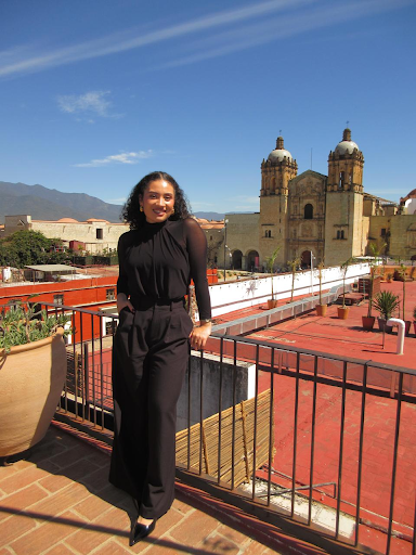 a photo of dioceline posing in front of an exquisite building