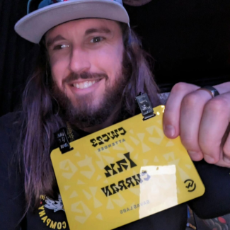 Ian holding his 2023 Creative Works Conference name badge