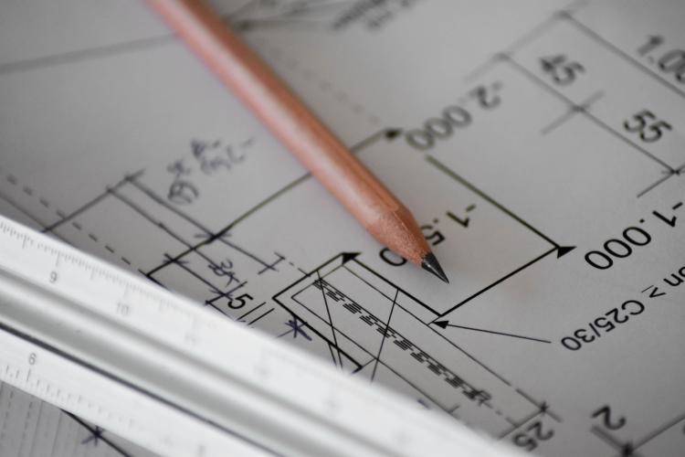 Photo of a pencil and ruler on top of a construction blueprint.