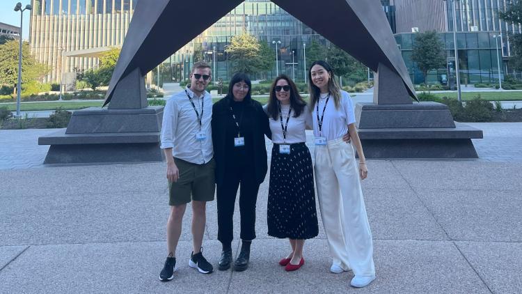 The Savas Labs Project Management Team standing in front of a large star statue